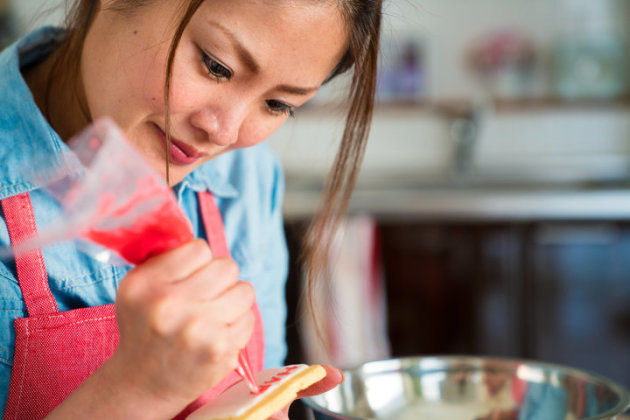 Young woman icing a cookie. Osaka, Japan. February 2017
